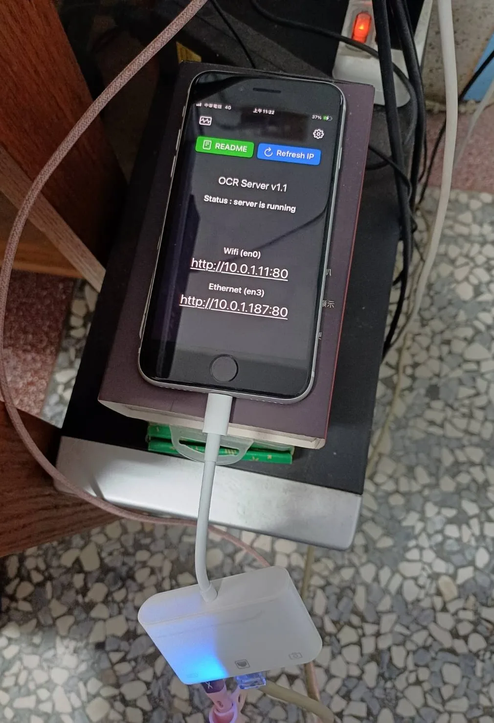 iPhone 螢幕顯示 OCR Server App 介面，狀態列寫著 server is running，並列出 Wi-Fi 與 Ethernet 兩個網路介面的伺服器網址，手機以傳輸線與其他設備相連